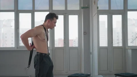 Young man attaching hook rope while standing shirtless in front of mirror Stock Footage 308661149