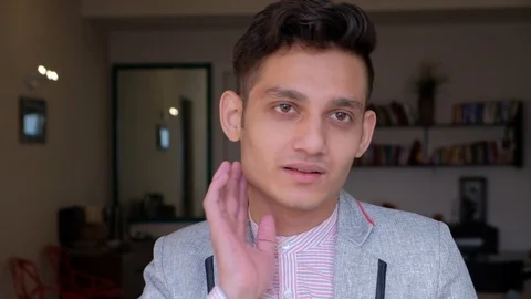 Young man attentively talks to someone off camera in a serious and sombre mood  Stock Footage 101286863