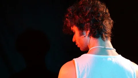 Young man from the back dressed dressed in a white tank top moves his head down  Stock Footage 126856017