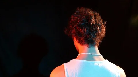 Young man from the back dressed dressed in a white tank top moves his head down  Stock Footage 126858404