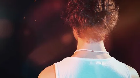 Young man from the back dressed  in a white tank top moves his head down on warm Vídeo Stock 127721546