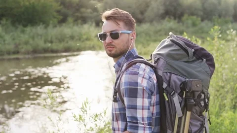 Young Man With a Backback Standing and Looking Around Stock Footage 77678601