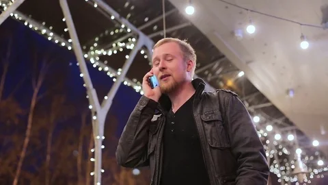 The young man in the background of the city at night talking on the phone Stock-Footage 75045544