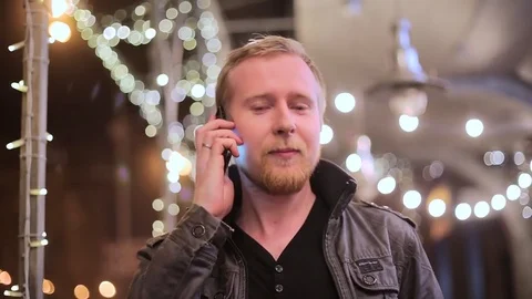 The young man in the background of the city at night talking on the phone Stockbeeldmateriaal 75045759