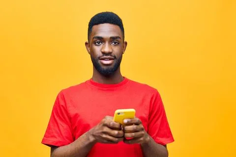 Young man background internet black technology yellow mobile african happy Stock Photos