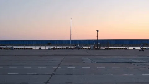 A young man with a backpack alone on an electric scooter passes the entire frame Stock Footage 118966680