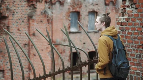 A young man With backpack on back walks through the park in the spring or autumn Stock Footage 74109894