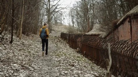 A young man With backpack on back walks through the park in the spring or autumn Stock Footage 74110289