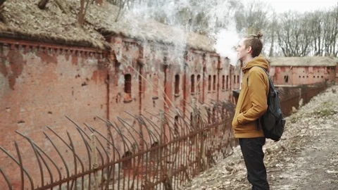A young man With backpack on back walks through the park in the spring or autumn Stock Footage 74110440
