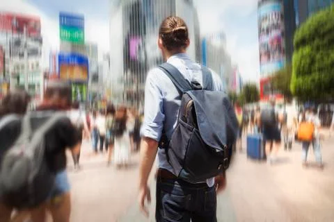 A young man with a backpack on a crowded street in downtown Tokyo. Stock Photos