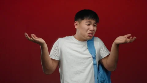 Young man with backpack gesturing on red background suggestively expressing.. Stock Footage 308585899