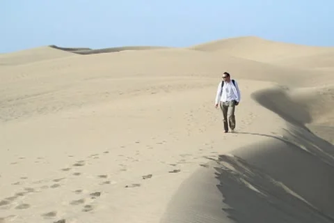 Young man with backpack hiking in the desert NTSC Stock Footage 10901837