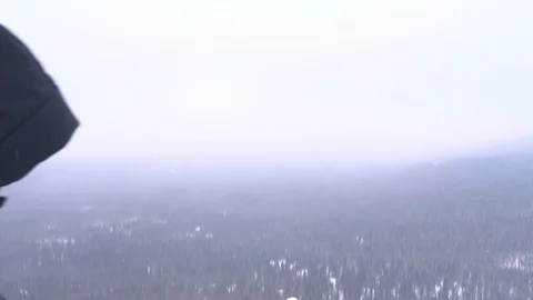 A young man with a backpack on his shoulders rises to the top of a snow-covered Video stock 104500508