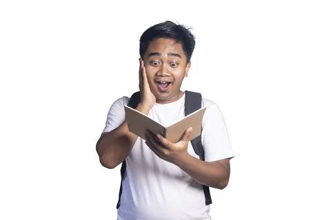 Young man with a backpack holding an open notebook while touching his face .. Stock Photos