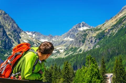 Young man with backpack looking at mountain peaks Stock Photos
