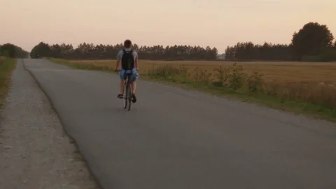 Young man with backpack riding a bicycle outdoors. Stock Footage 83121968
