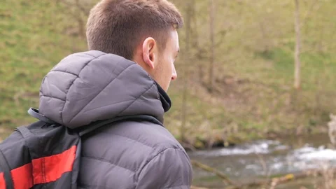 Young man with backpack walking in the mountain forest near to mountain river. Stock Footage 106776685