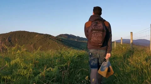 Young man with backpack walking on paths Stock Footage 130854730