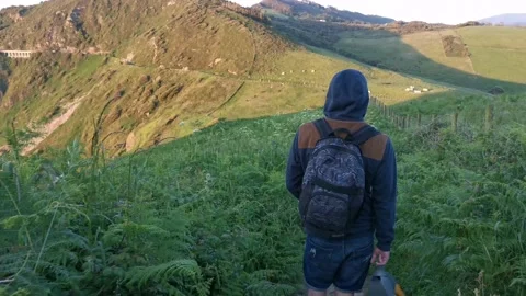 Young man with backpack walking on paths Stock Footage 130855124