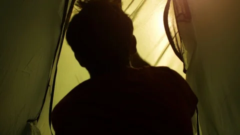 Young man backpacker exits camping tent in front of roman aqueduct arches in Stock-Footage 86294393