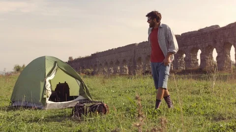 Young man backpacker relaxing lying on grass ouside camping tent on in front of 스톡 동영상 86285308