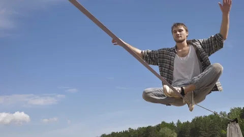 Young man Balancing and jumping On A Slackline At Sea Shore Sand Beach Healthy Видео 91251887