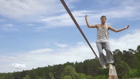 Young man Balancing and jumping On A Slackline At Sea Shore Sand Beach Healthy Видео 91252050