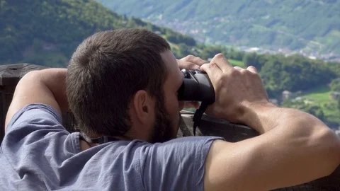 Young Man on Balcony Using Binoculars, Close Up Stockbeeldmateriaal 79005702