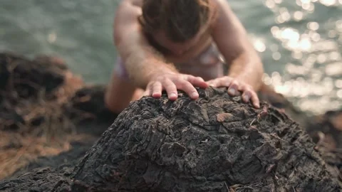 A young man with a bare torso, with tension climbs the rock. Video stock 234020491