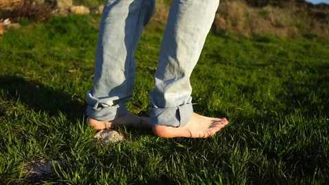 Young man barefoot walking over fresh grass Stock Footage 88964537