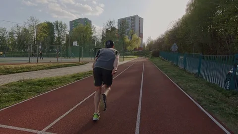 Young Man in Baseball Cap Running Fast On Red Track Slow Motion Stock Footage 114070279