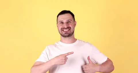 Young man in basic look camera pointing fingers. Thumb up. Video stock 251639713