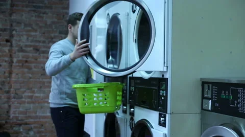 Young man with basket in the laundry Video stock 64954238