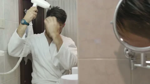 Young man in bathrobe drying his hair in bathroom Video stock 64764281