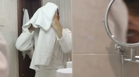 Young man in bathrobe drying his hair in bathroom 库存影片 64767265