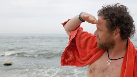 Young man with a beard and blue eyes on the background of the sea with a towel Stock Footage 108112709