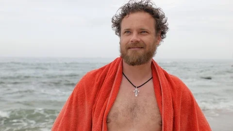 Young man with a beard and blue eyes on the background of the sea with a towel Stock Footage 108112716