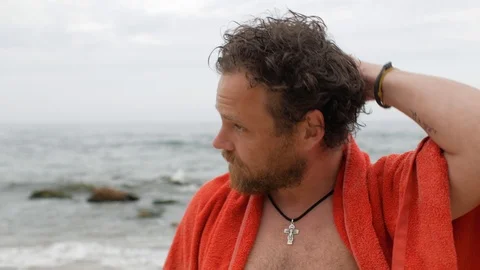 Young man with a beard and blue eyes on the background of the sea after bathing Stock Footage 108112798