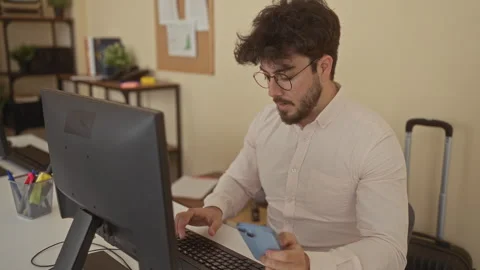 Young man with beard and glasses explores smartphone while working in a mod.. Stock Footage 312349026