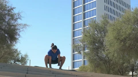 Young man with beard and ponytail performing stretching exercises in an urb.. Stock Footage 229727736