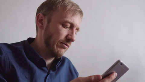Young man with a beard calls on a mobile phone Stock Footage 128304612
