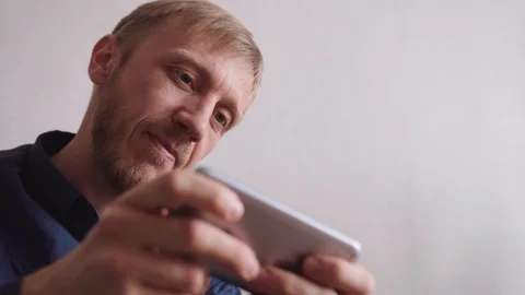 Young man with a beard calls on a mobile phone Stock Footage 128304917