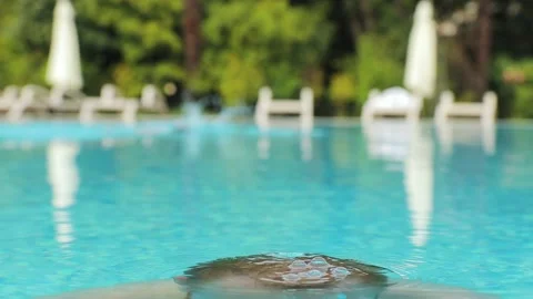 Young man beard dive and emerge in a hotel pool in swimming goggles Stock-Footage 147040699