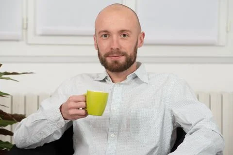 Young man with a beard drinking cup of coffee Stock Photos