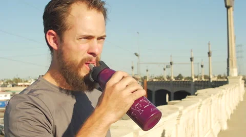 A young man with a beard drinking water and working out in urban environment. Stock Footage 67981300