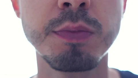 Young man with beard is eating and chewing chocolate close up 4K Stock-Footage 220560797