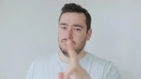 Young man with a beard gesturing with his finger to indicate denial Stock Footage 306259360