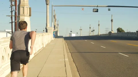 A young man with a beard going for a run in an urban environment, slow motion. Stockbeeldmateriaal 68537164