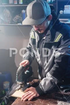 Young man with a beard in gray overalls and goggles by profession a carpenter Stock Photos