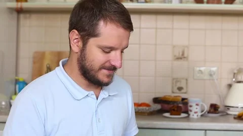 Young man with a beard, holding in his hands a sweet and savory pastries. With a Stock Footage 68036088